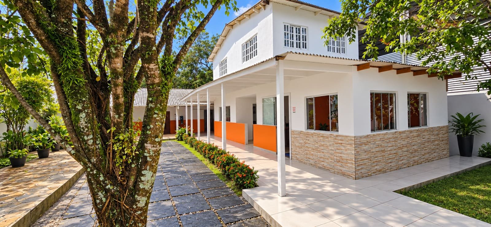 Fachada da sede da Integradas Educacional em Ubatuba, com varanda e jardim